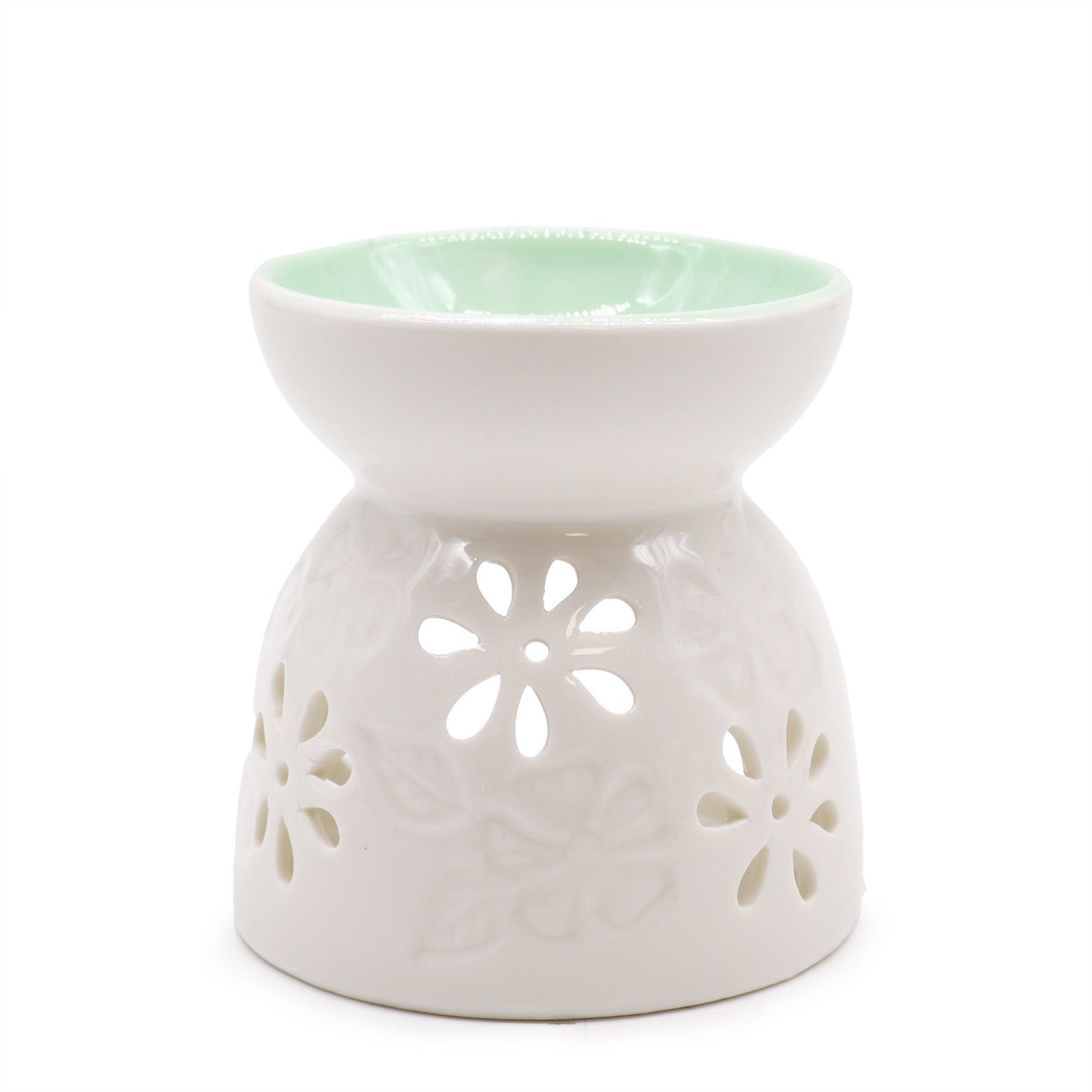 Close-up of a glossy white ceramic oil burner with petal-shaped cut-outs