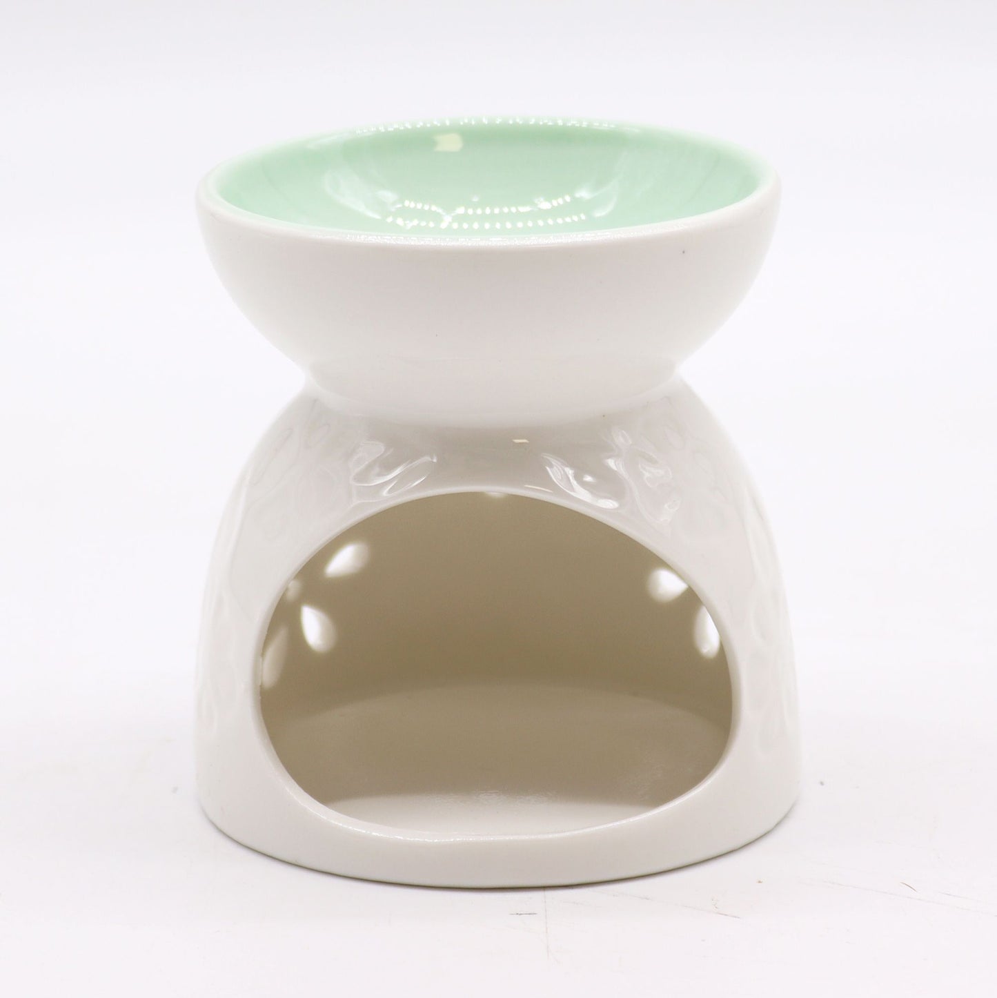 Close-up of a glossy white ceramic oil burner with petal-shaped cut-outs