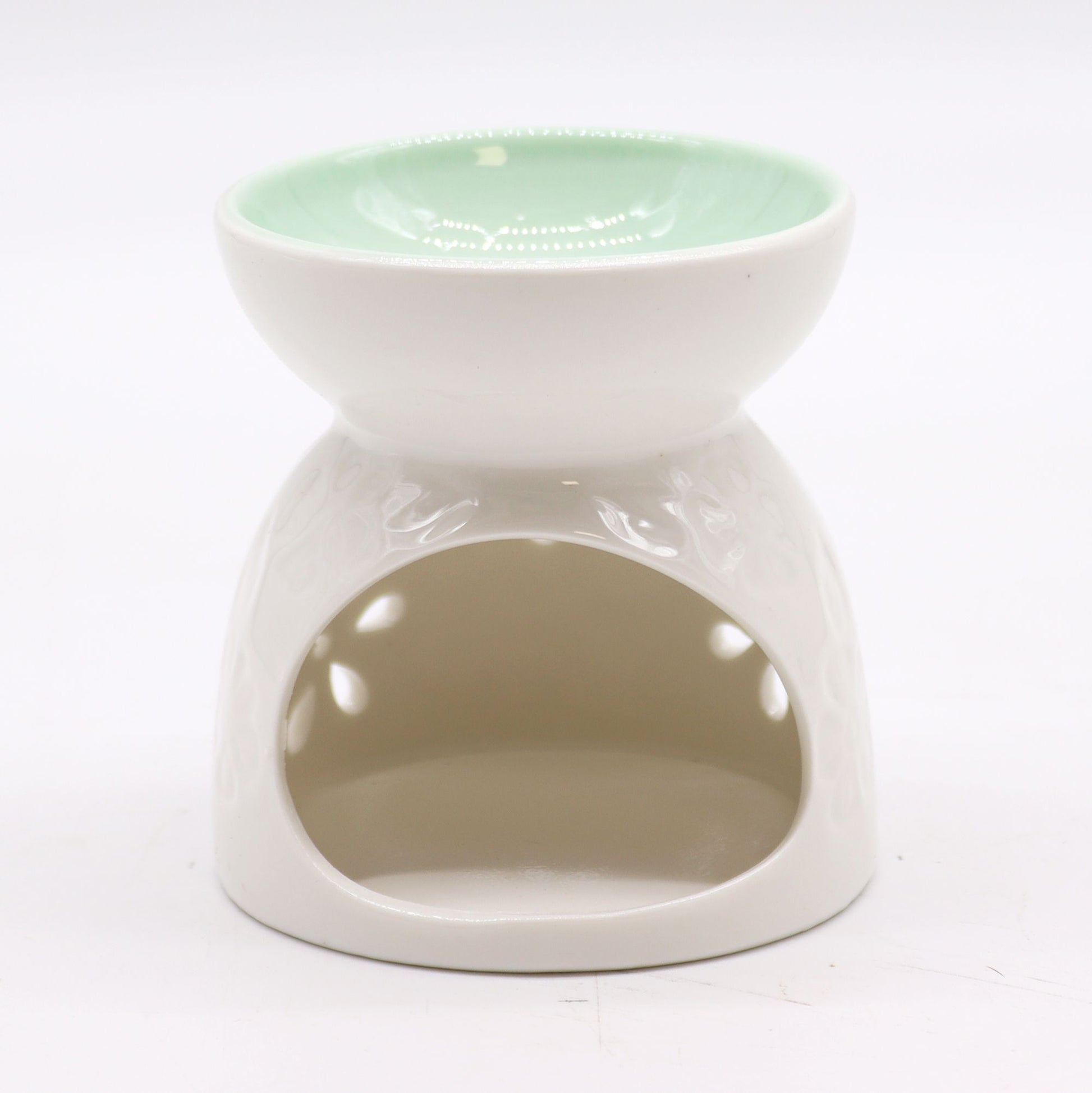 Close-up of a glossy white ceramic oil burner with petal-shaped cut-outs