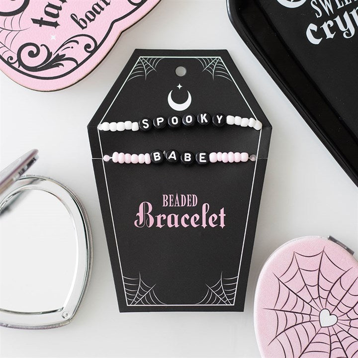 2 bracelets saying spooky and babe on a black coffin card holder