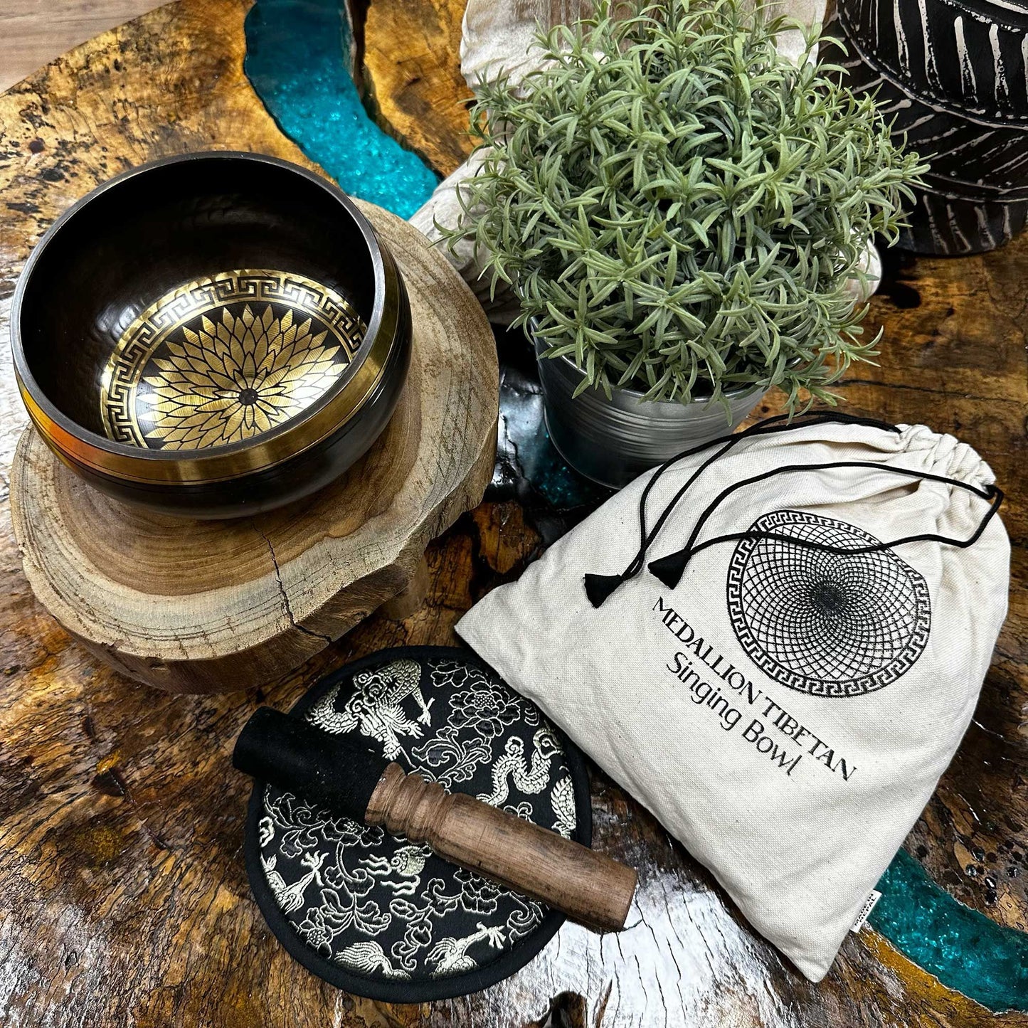 Tibetan singing bowl set with decorative bag on a wooden surface