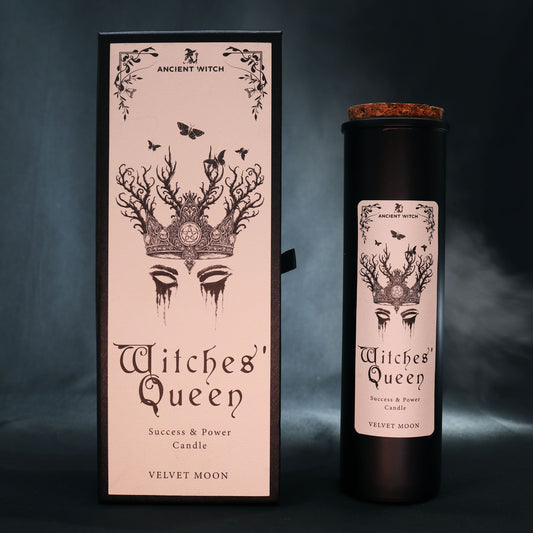 Witches' Queen candle packaging with pink box and black candle on a dark background