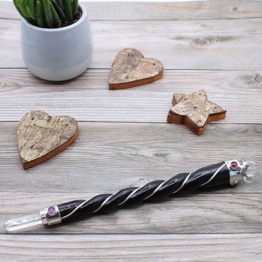healing wand on a wooden table with coasters and a plant