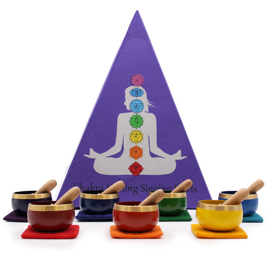 Set of chakra singing bowls with corresponding colors and a purple pyramid with chakra symbols on a white background.