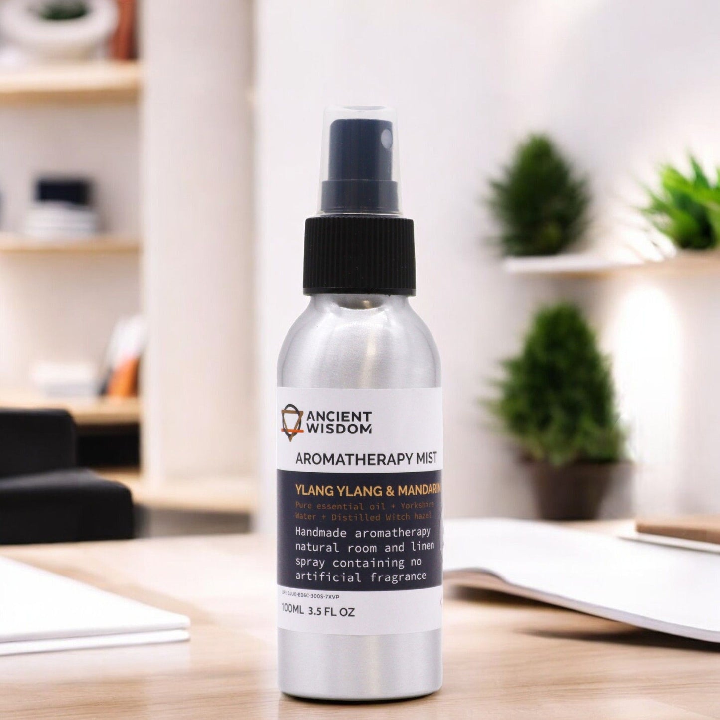 Brushed-aluminium spray bottle with black atomiser labelled ‘Aromatherapy Mist—Ylang Ylang & Mandarin’; a natural room and linen spray made with Yorkshire water, distilled witch hazel, ylang ylang flower and mandarin peel essential oils.