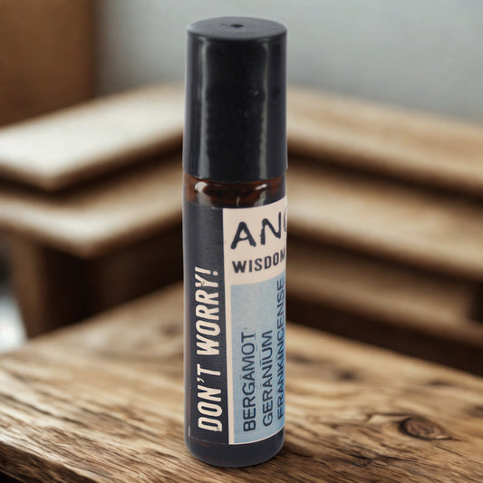 Small amber roller bottle with stainless steel ball and black cap, ‘Don’t Worry!’ label listing bergamot, geranium and frankincense—pre-diluted aromatherapy roll-on for wrists, temples and neck.