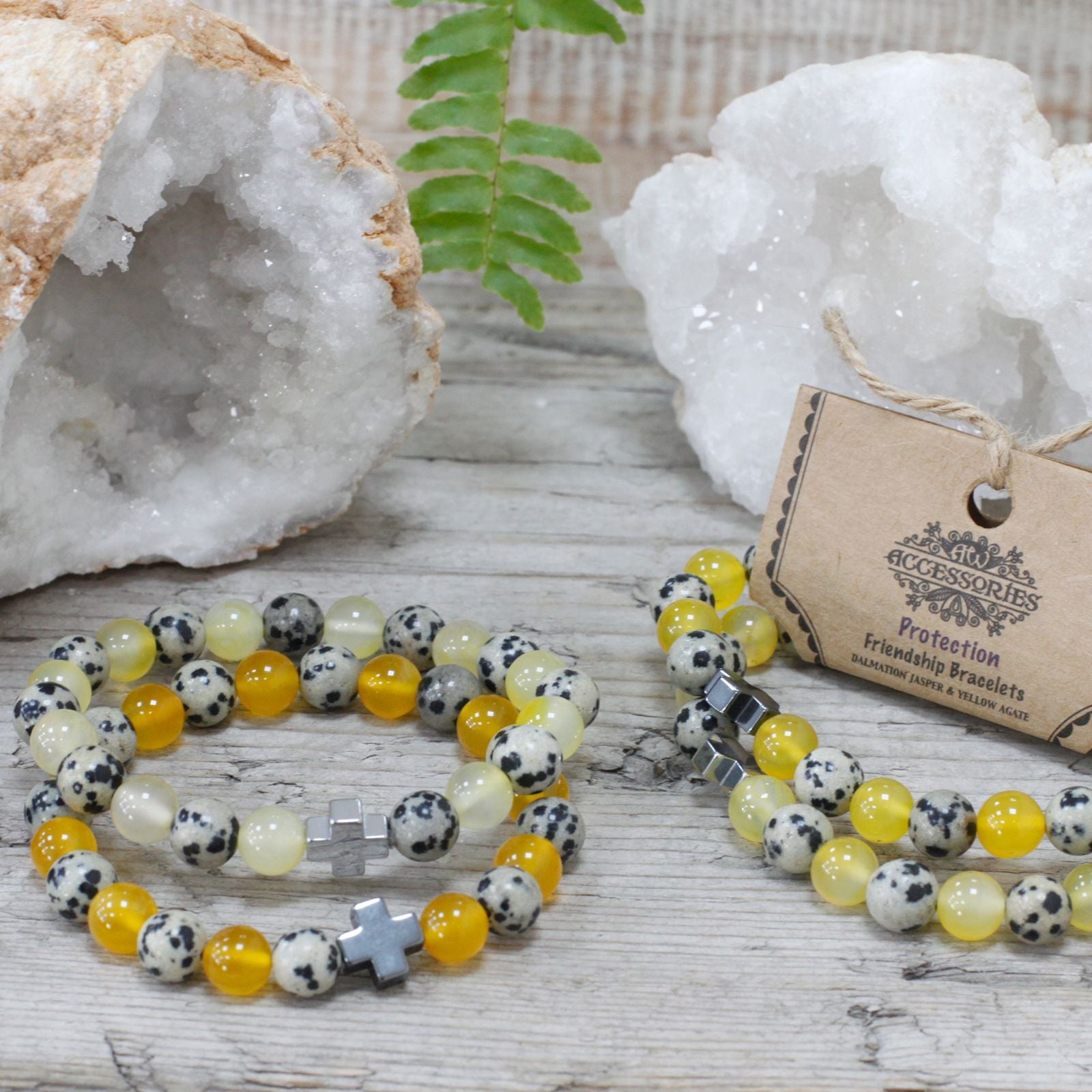 Pair of Dalmatian Jasper and Yellow Agate friendship bracelets on rustic tabletop with geode crystals.