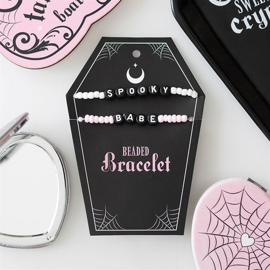 2 bracelets saying spooky and babe on a black coffin card holder