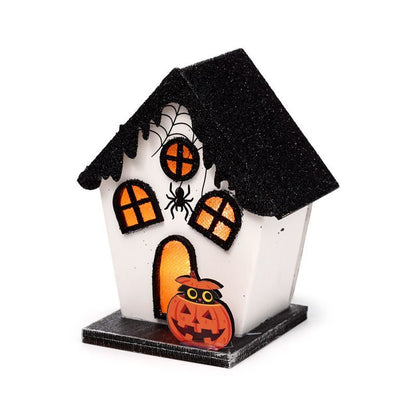 Small white haunted house with glittery black roof, spider web windows and warm LED glow.
