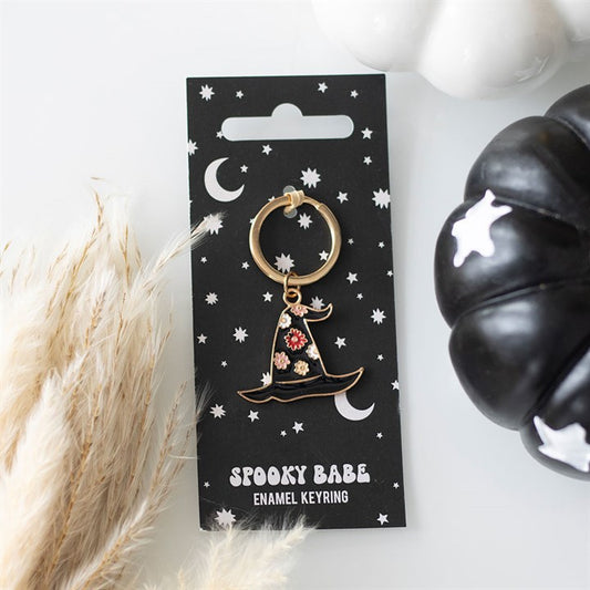Spooky Babe enamel keyring on a black card with decorative elements