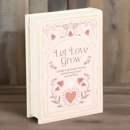 Faux book storage box 'Let love grow' pale pink on a wooden table - fae cottage