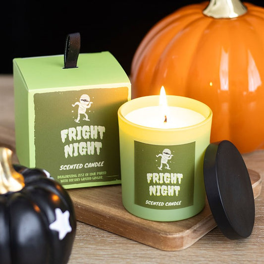 Fright Night scented candle with packaging and pumpkins on a wooden surface