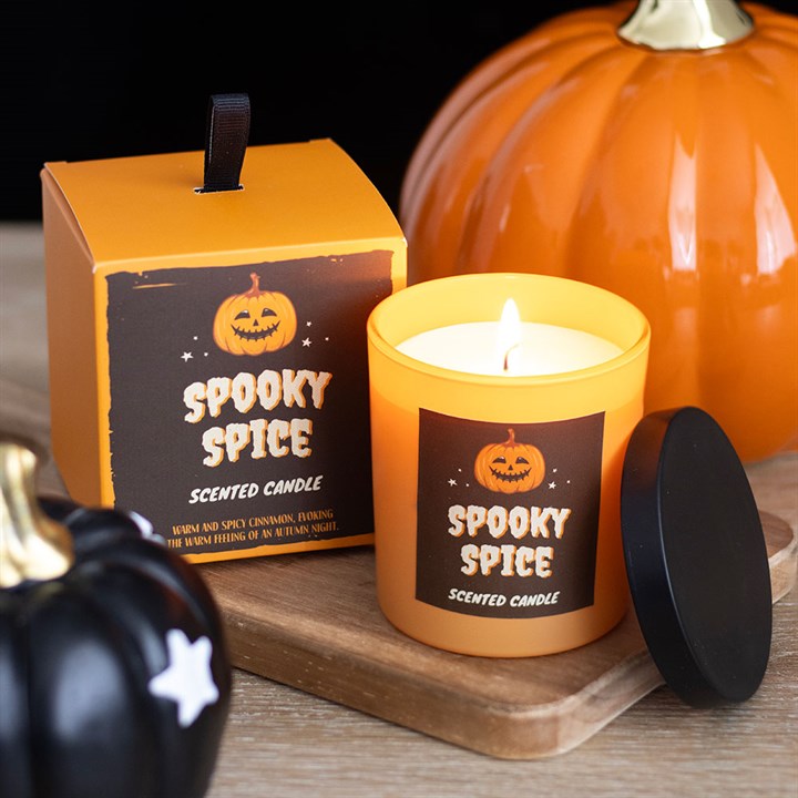 Spooky Spice scented candle with packaging and pumpkins on a wooden surface
