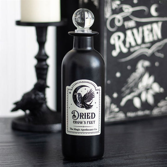 Black bottle labeled 'Dried Crow's Feet' with decorative elements on a dark surface.