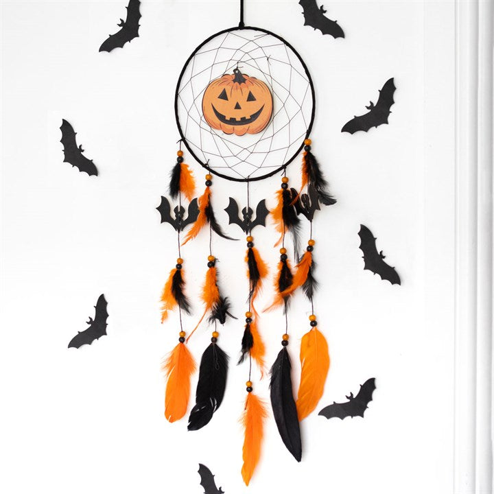 Halloween-themed dreamcatcher with a pumpkin and feathers on a white background with bats.