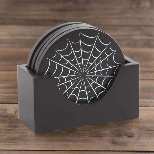 Set of black coasters with spider web design in a holder on a wooden table