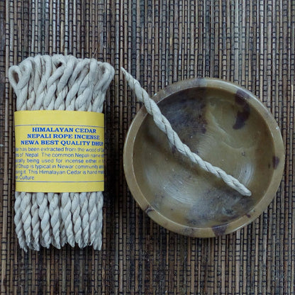 Himalayan Cedar Nepali rope incense with packaging on a woven mat