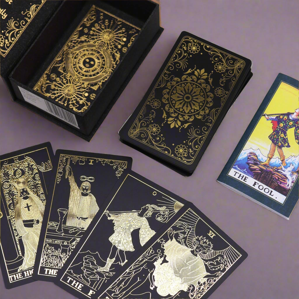 Black tarot cards with gold designs and a few cards displayed on a lilac background.