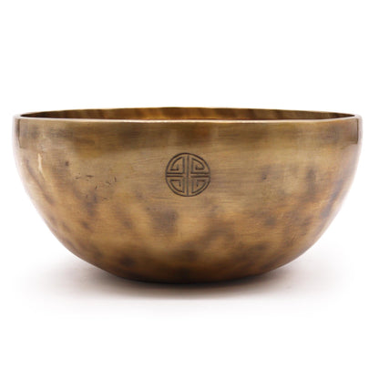 Bronze singing bowl with a symbol on a white background