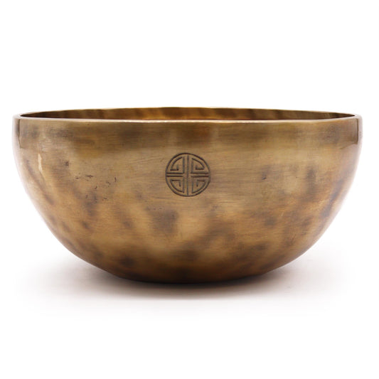 Bronze singing bowl with a symbol on a white background