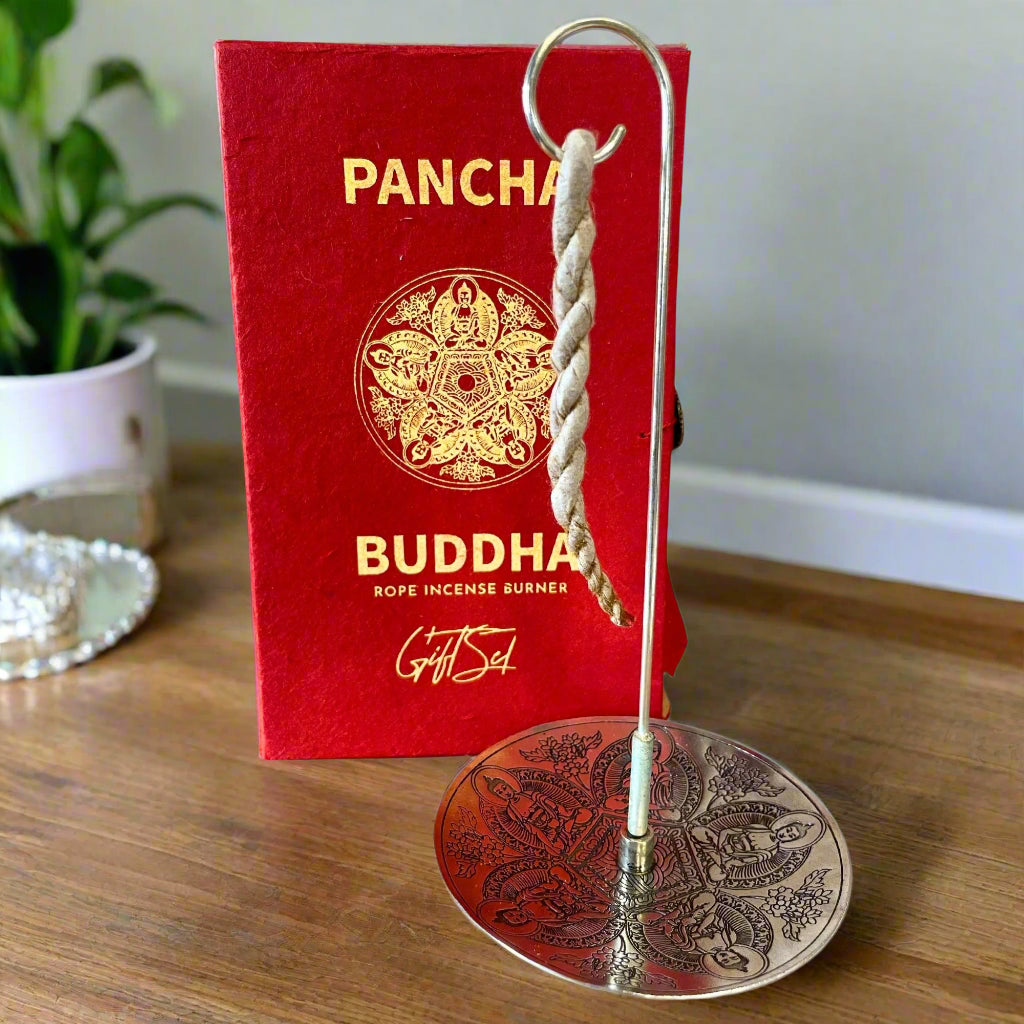 Buddha rope incense burner with red packaging on a wooden surface.