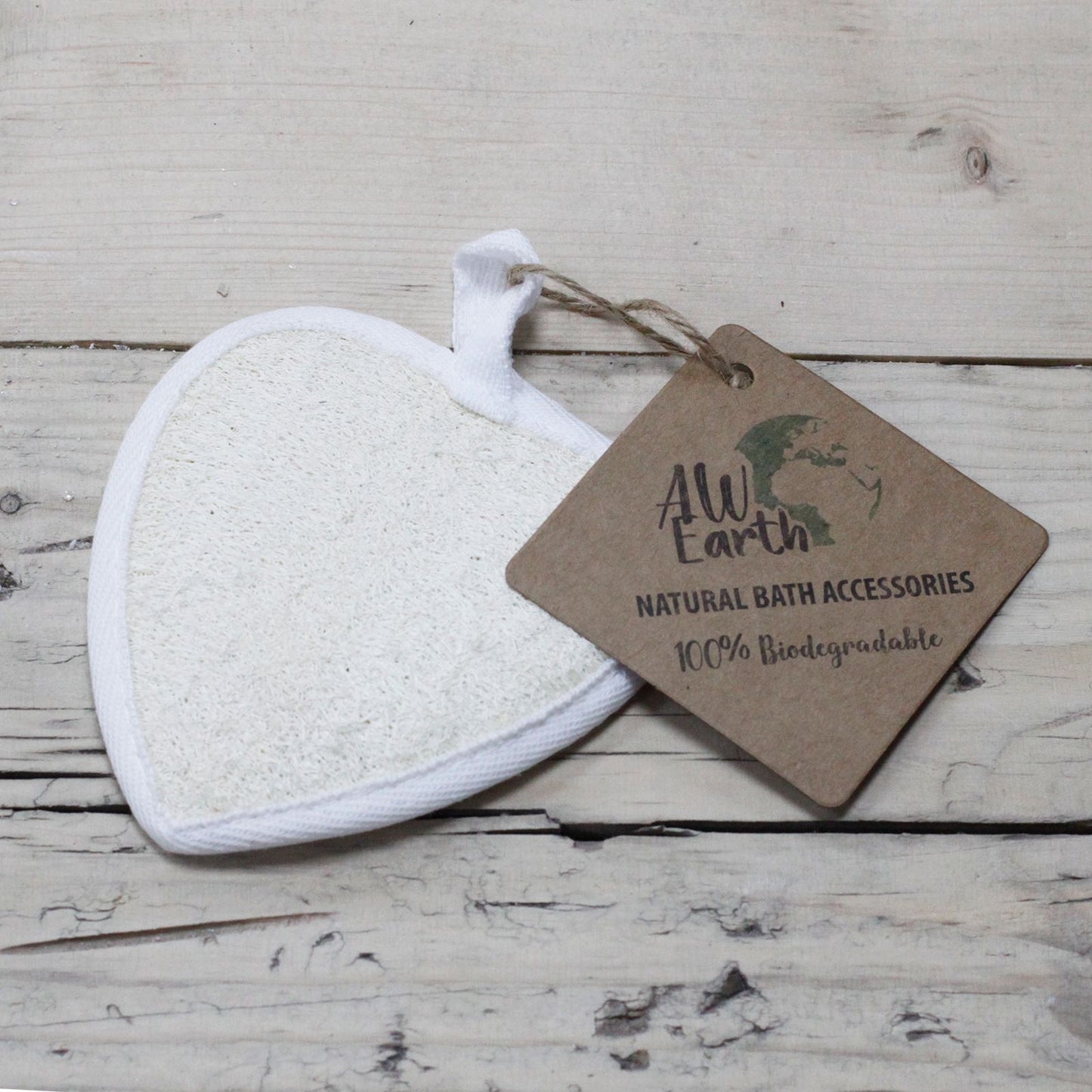 White bath pouf with a 'AwEarth' tag on a wooden surface