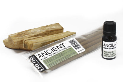 Incense sticks and essential oil bottle labeled 'Ancient' on a white background