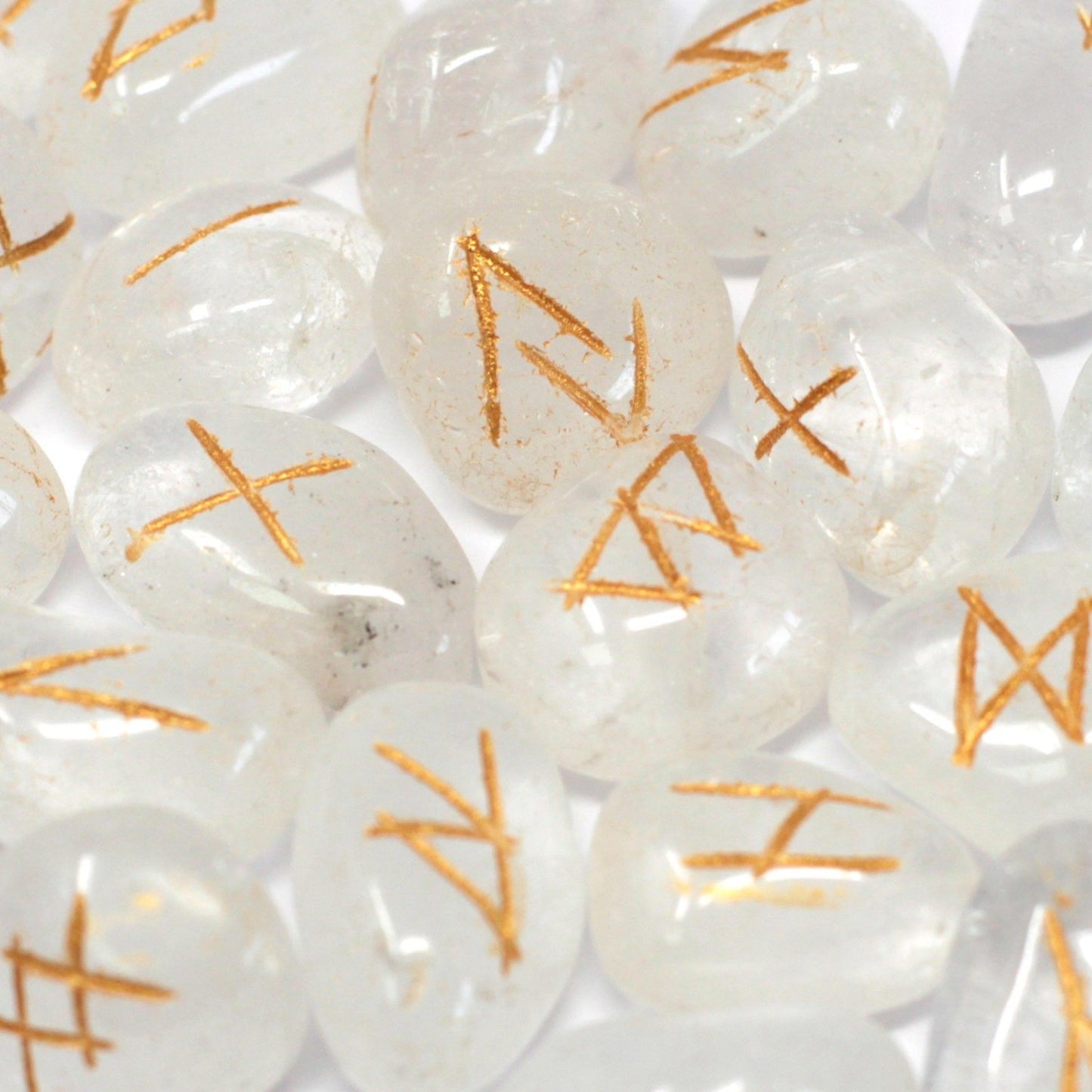 Close-up of white stones with orange runes on a white background