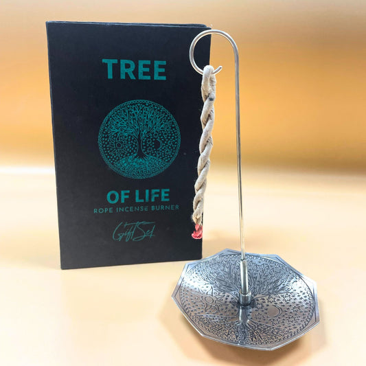 Decorative metal incense burner with 'Tree of Life' branding on a blurred background