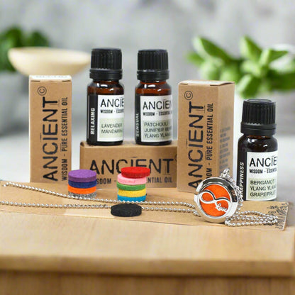 Essential oil bottles and packaging on a wooden surface with a blurred background