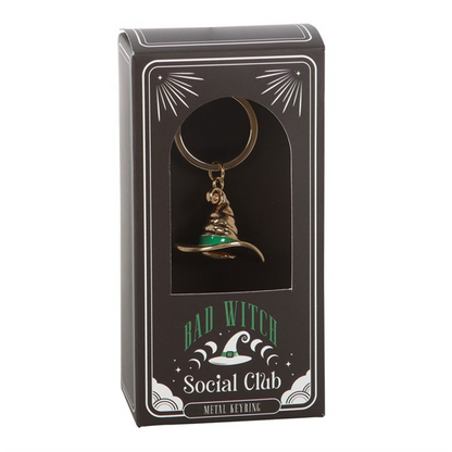 Gold-tone witch hat keyring with green enamel band on a split ring, presented in a “Bad Witch Social Club” gift box.