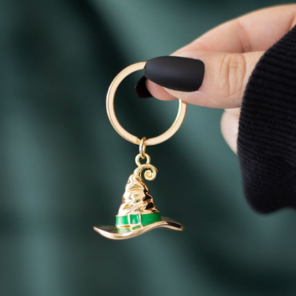 Gold-tone witch hat keyring with green enamel band on a split ring