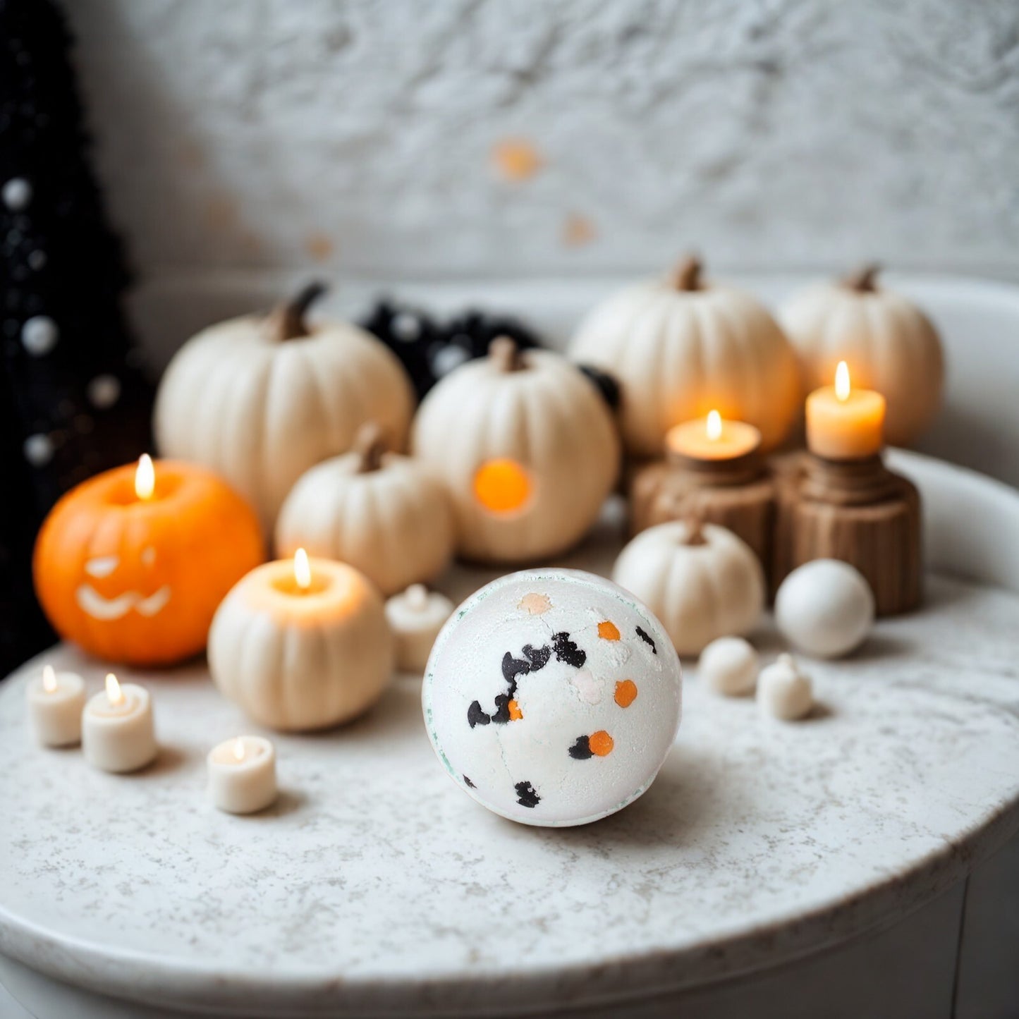 Mint-green spherical Halloween bath bomb with black bat and orange pumpkin sprinkles; coconut & lime scent; handmade in the UK.
