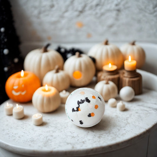 Mint-green spherical Halloween bath bomb with black bat and orange pumpkin sprinkles; coconut & lime scent; handmade in the UK.