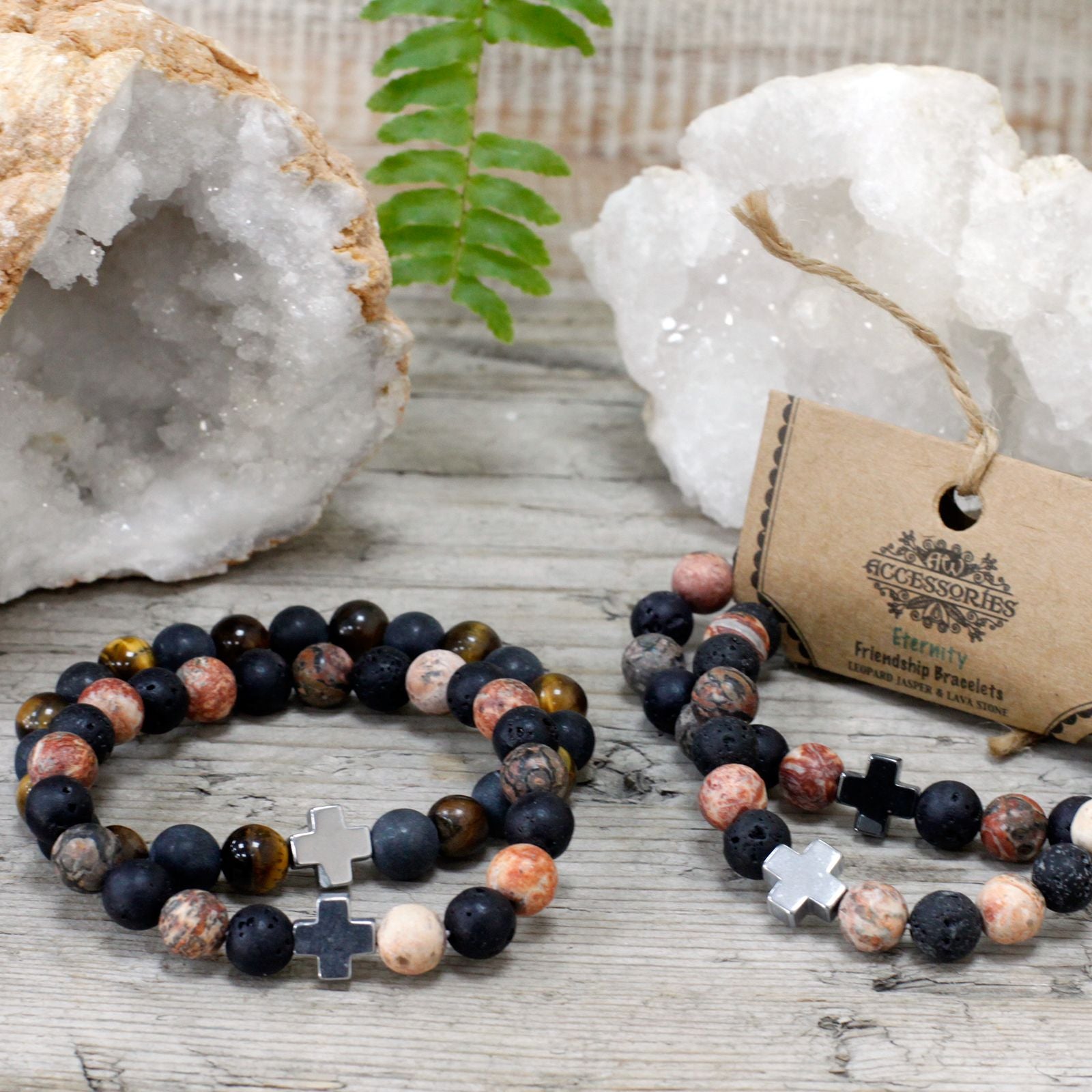 Pair of Leopard Skin Jasper and Lava Stone friendship bracelets styled beside crystal geodes on a wooden surface.