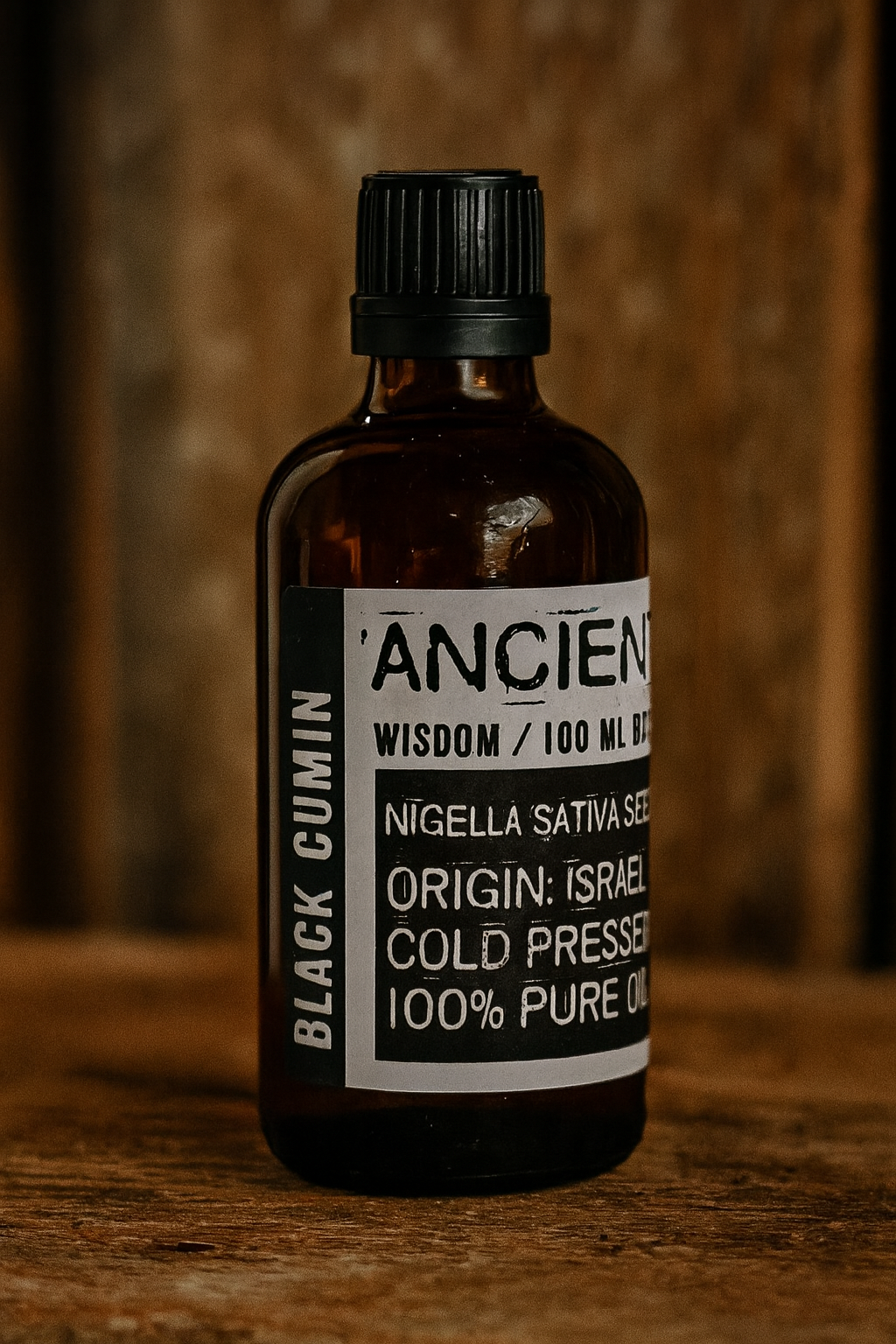 Amber glass bottle with black cap labelled ‘Black Cumin—cold-pressed’; deep golden, spicy-herbal Nigella sativa seed oil for face, body and scalp blends.