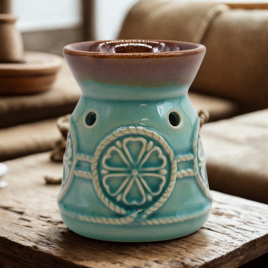 Turquoise ceramic spa oil burner with rosette motif on a rustic table in a cosy room.