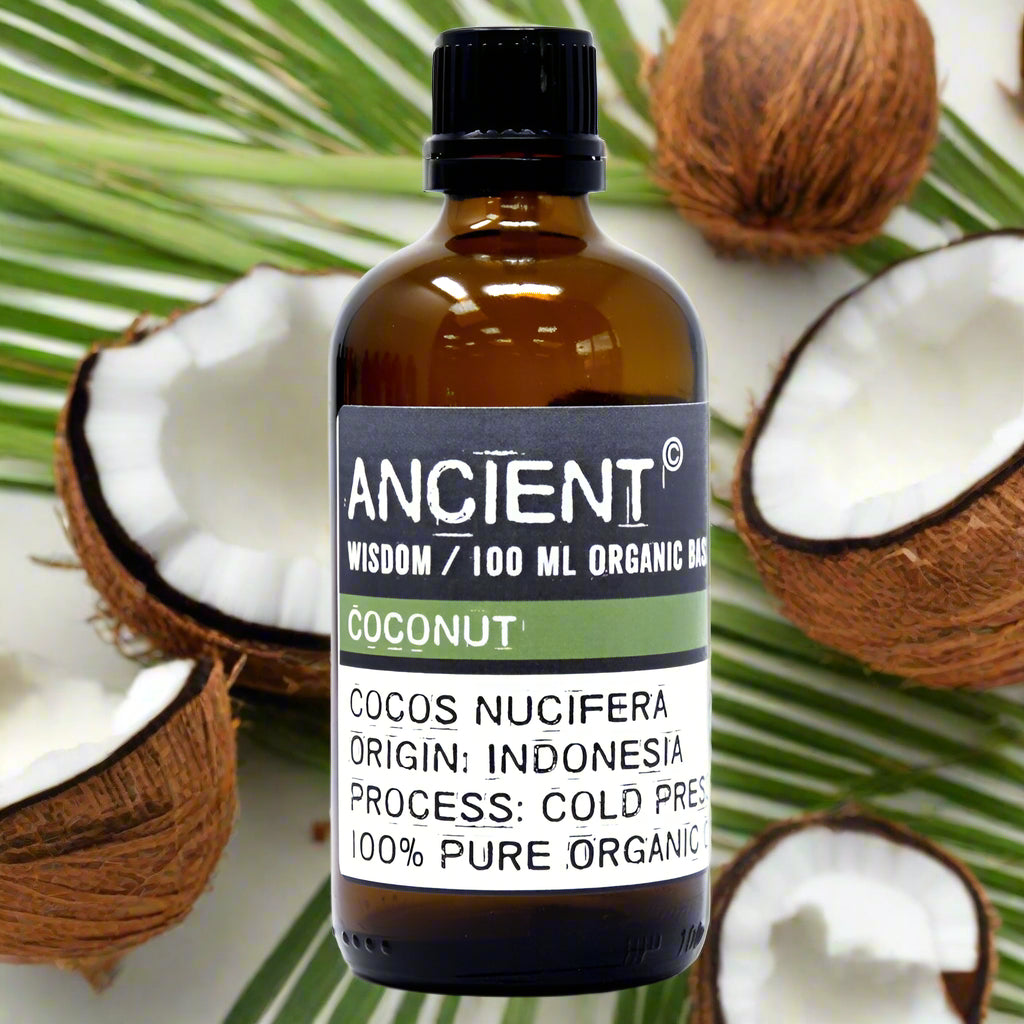 Amber glass bottle with black cap labelled ‘Coconut—100 ml organic base oil’; cold-pressed Cocos nucifera oil from Indonesia, semi-solid at cool temps and melts clear.