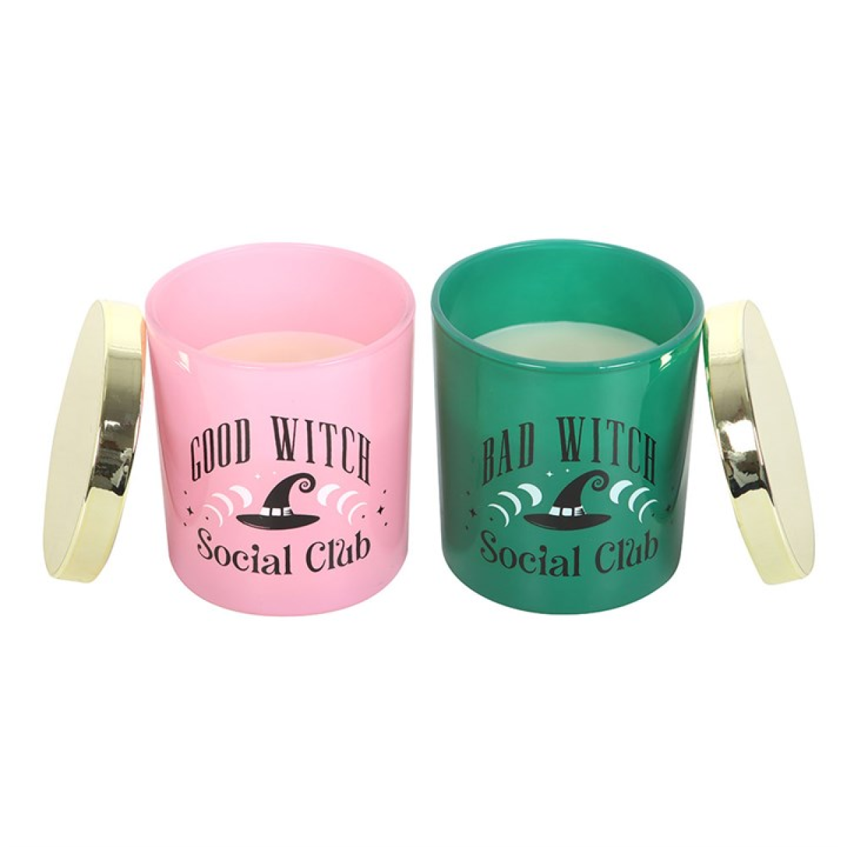 Two scented glass candles, one pink “Good Witch” and one green “Bad Witch,” lit and displayed with gold lids; giftable set.