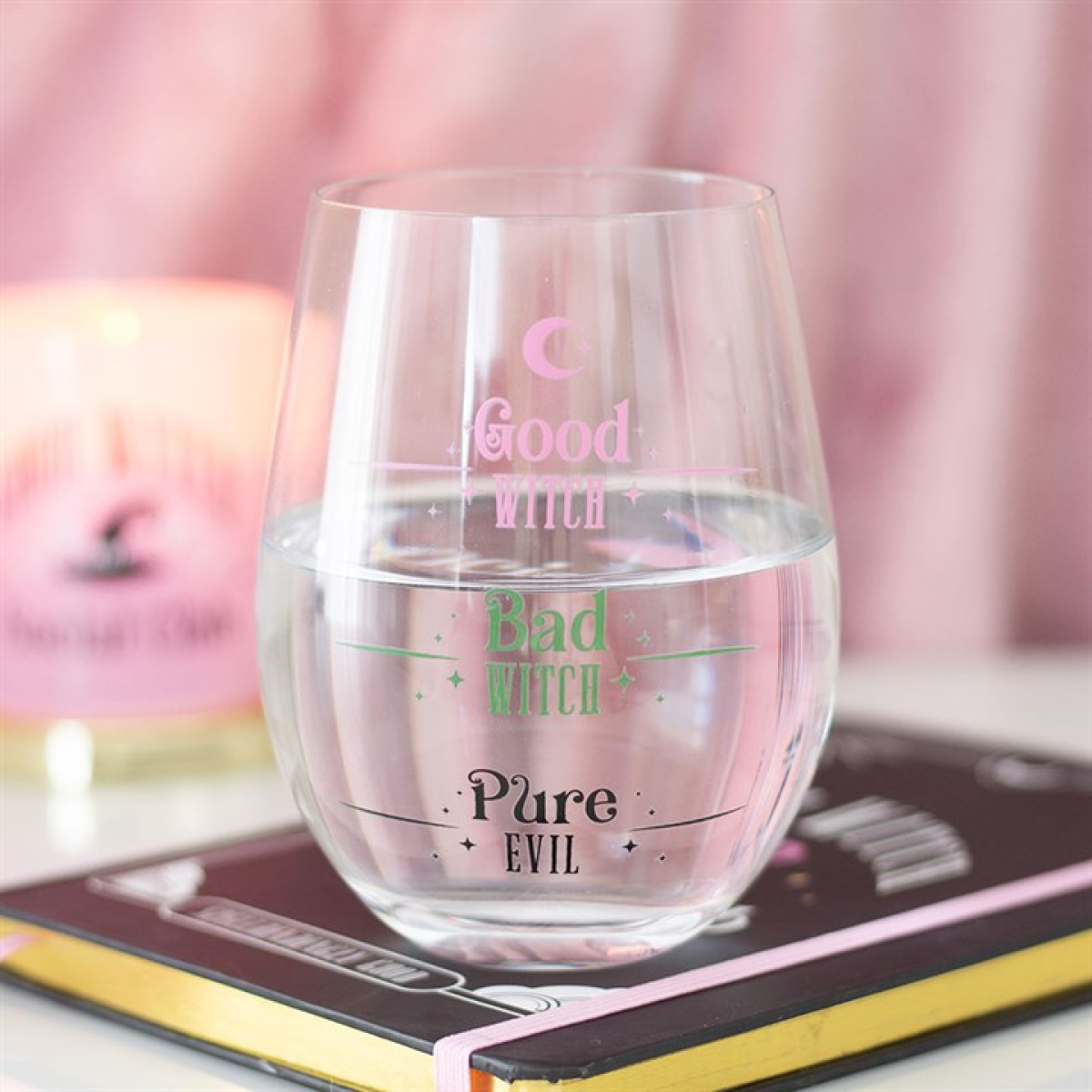 Clear stemless glass with pastel pink “Good Witch,” green “Bad Witch,” and black “Pure Evil” fill lines.