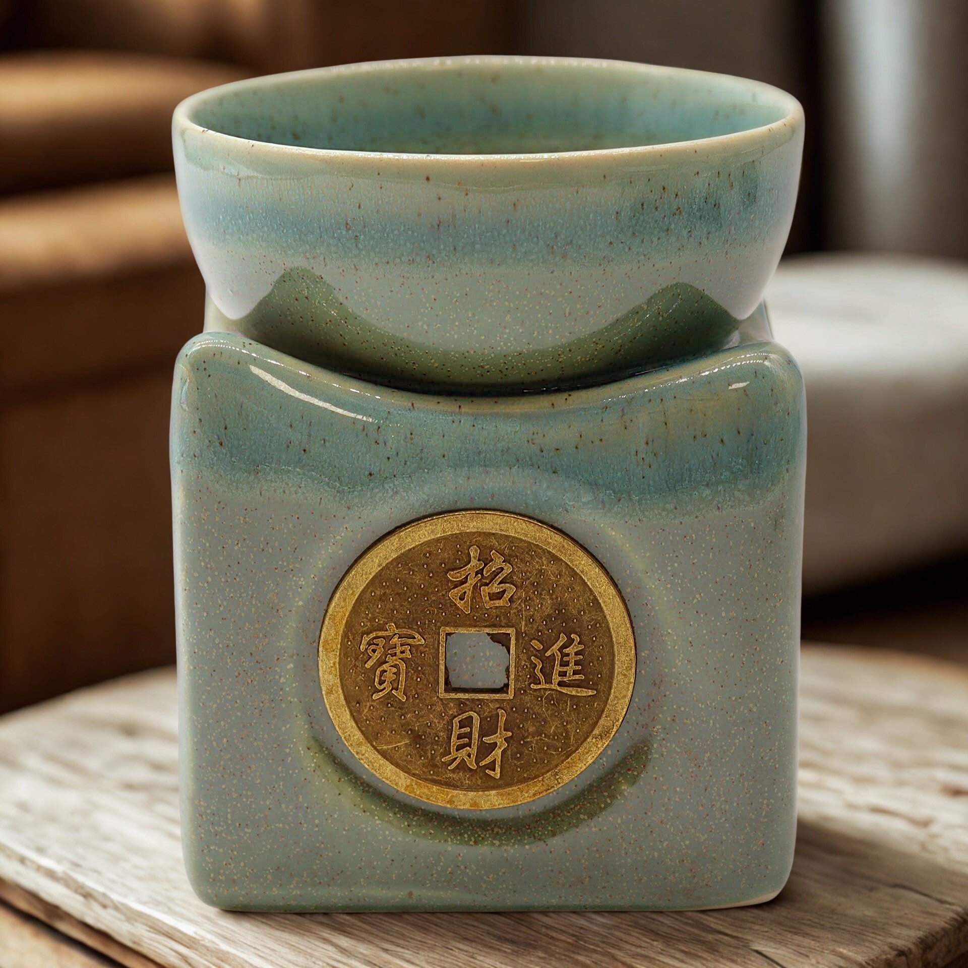 Lifestyle shot of the jade burner on a wooden surface; the prosperity coin emblem is centred and the bowl is seated on top.