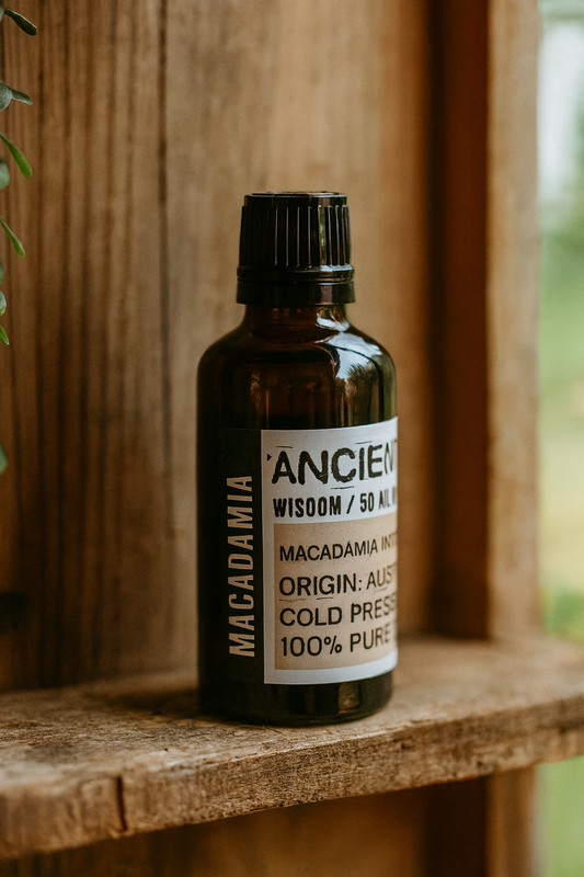 Amber glass bottle with black cap labelled ‘Macadamia—cold-pressed’; a clear, slightly yellow Macadamia integrifolia seed oil from Australia with a sweet nutty aroma and rich, slow-absorbing glide.