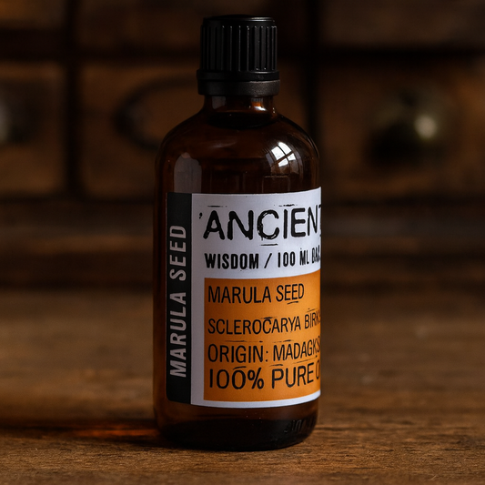 Amber glass bottle with black cap labelled ‘Marula—cold-pressed’; a pale golden, mildly nutty Sclerocarya birrea seed oil with a satin, fast-absorbing finish for face, body and hair blends