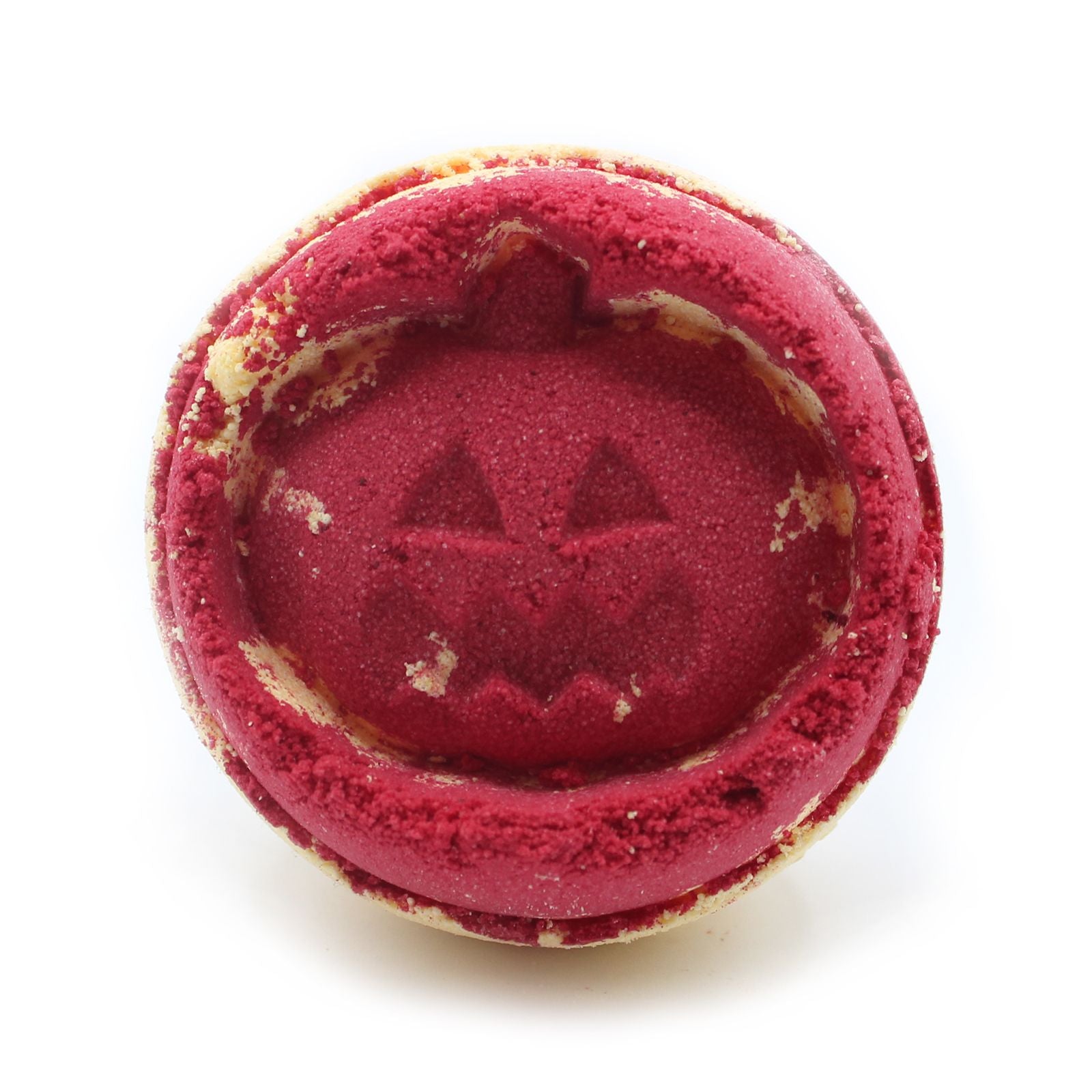 Close-up of a red jack-o’-lantern pumpkin bath bomb, handmade in the UK with aniseed fragrance.