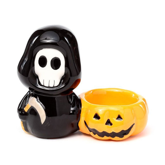 Ceramic Skull Boy tealight holder facing forward with pumpkin bowl at side.