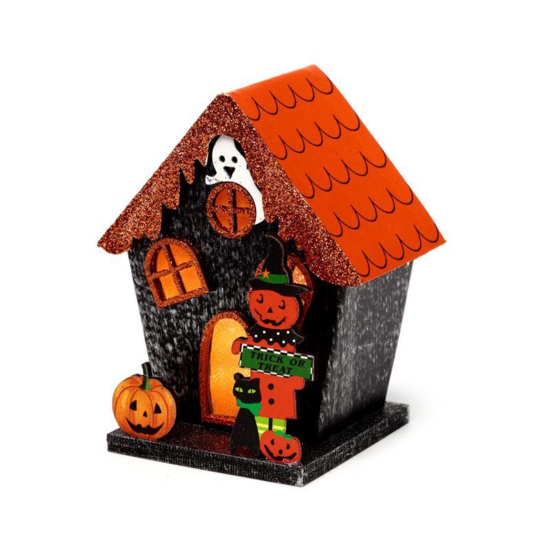 3/4 view showing orange roof, glittered eaves, jack-o’-lantern figure in a witch hat, black cat, and lit doorway.